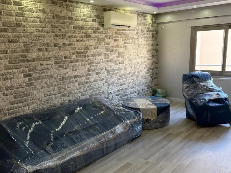 Ambalajlanmış koltuk ve mobilyalar yeni evde yerleştirilmeyi bekliyor
